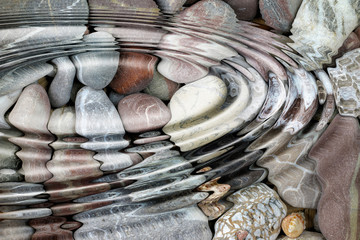 Water ripples over the stone pebbles