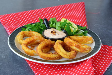 Calamary rings fried with spicy souce and rocca. Mediterranean lifestyle. Healthy food
