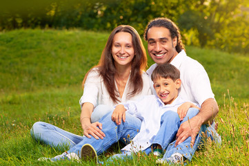 Fototapeta premium Obraz międzynarodowej rodziny siedzącej razem w parku