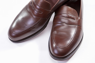 Footwear Concepts. Closeup of Pair of Stylish Brown Penny Loafer Shoes Against White Background.