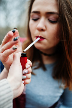 Hand of girl with cigarette lighter. Stop smoking social problem.