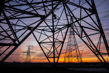 The silhouette of the evening electricity transmission pylon