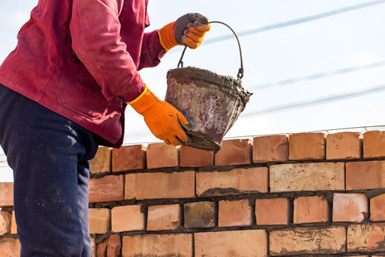Worker builds a brick wall in the house