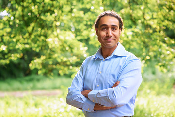 Portrait of a mature dark skin man standing with arms crossed