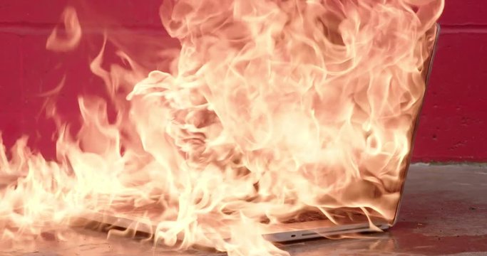 Laptop computer exploding into flames and burning intensely