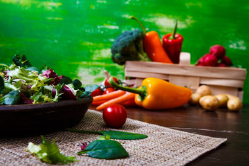 Provence mix salad. Leaves of endive or chicory, lamb and rose salad. Raw vegetables. On wooden table.