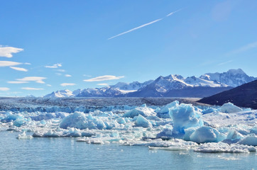 Single blue icebergs and blue sky with white clouds and mountains on the background. Upsala Glacier at Argentino Lake, Los Glaciares National Park, Patagonia, Argentina - 143134850