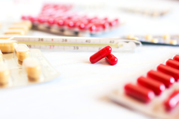 A lot of pills and a thermometer. disease
