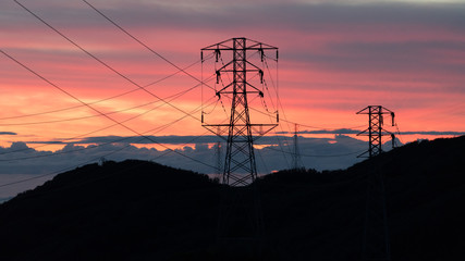 Sunset over Ocean Mountains Shape of Silhouette Electric Powerlines Towers
