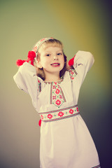 Closeup image of little beautiful girl in embroidered clothes