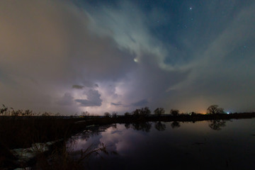Fototapeta premium Rain and lightning above the river