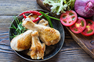 Toasted chicken legs with rosemary and tomato.