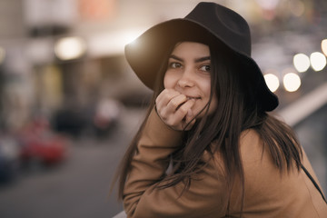 Funky woman in hat smiling and having fun, city background