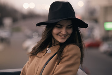 Funky woman in hat smiling and having fun, city background