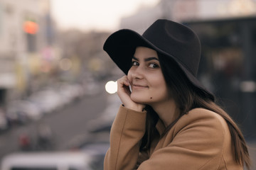Funky woman in hat smiling and having fun, city background