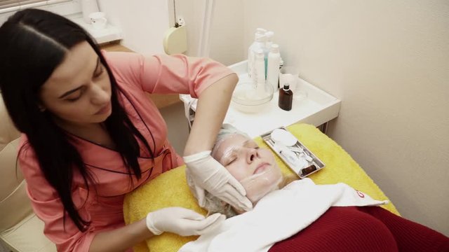 Beautician preparing woman for the therapy in beauty salon closeup