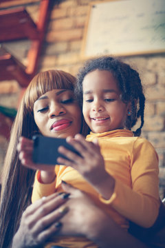 African Mother With Daughter Using Phone.