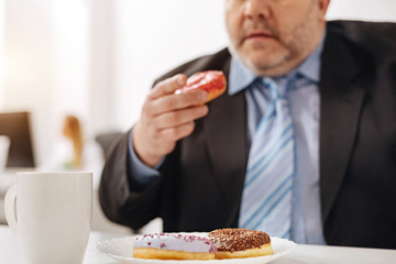 Corpulent will less man consuming doughnuts