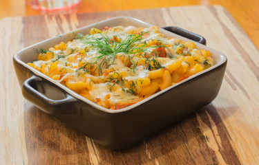 Macaroni or pasta with cheese and meat in square dish. Warm dish from the owen. Close up / macro photography.