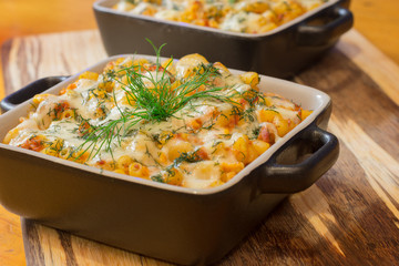 Macaroni or pasta with cheese and meat in square dish. Warm dish from the owen. Close up / macro photography.