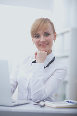 Portrait of businesswoman sitting at desk with a laptop