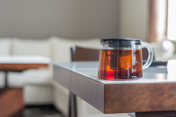 Transparent teapot on the white table. Natural light from the window.