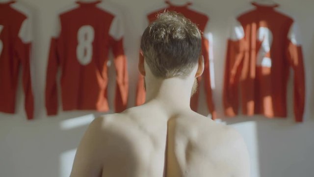 Sports man prepares to pay a game or match in changing room