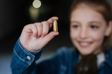 Obraz premium Selective focus of a bullet being held by a girl