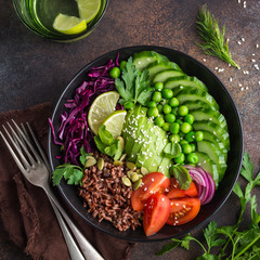 vegan lunch bowl. Avocado, red rice, tomato, cucumber, red cabbage, green peas vegetables salad