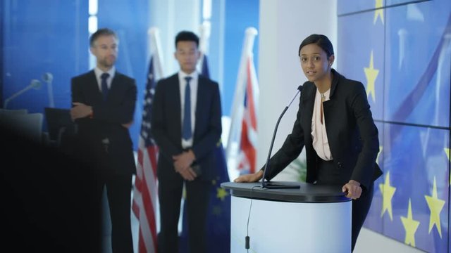  Politician answering questions at press conference, EU flag in background