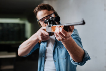 Nice pleasant man developing his shooting skills