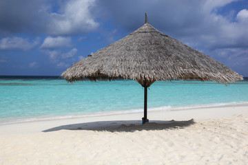 Beach umbrella made of straw in the secluded beach, Maldives
