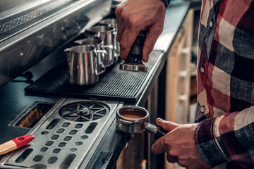  Close up image of a man making coffee.