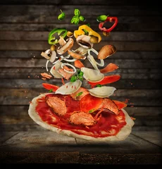 Photo sur Plexiglas Pizzeria Flying ingredients with pizza dough, on wooden background