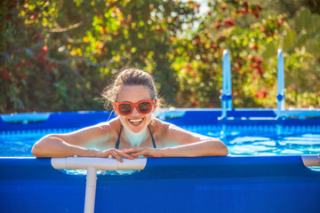 happy healthy woman in swimming pool in sunglasses