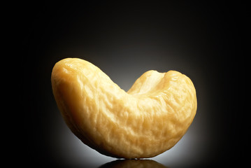 Cashew on black background with reflection. Close-up or macro. Health concept