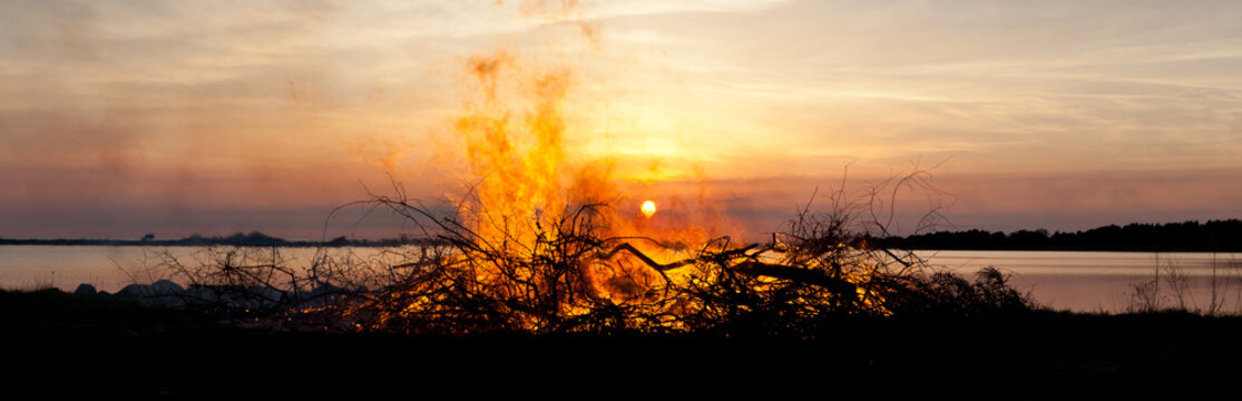 panorama av majbrasa vis havet, siluett mot solnedg&aring;ngen Valborgsm&auml;ssofirande