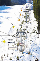 Chair ski lift elevator lifting people on the mountain ski slope Bansko Bulgaria ski centre 
