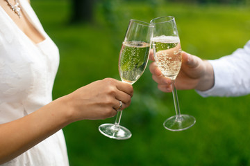 Wedding couple with champagne glasses clink