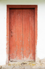 old house white wall with red door