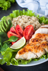 Fresh salad from quinoa, chicken breast, spinach, lettuce and tomatoes.