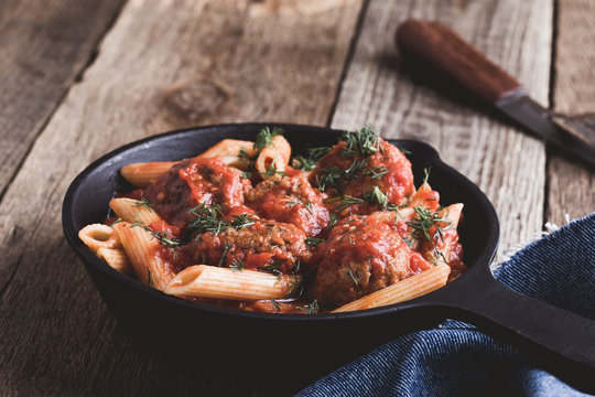 Meatball penne pasta with spicy tomato sauce and dill
