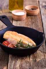 Fried chicken breast on skillet with tomatoes