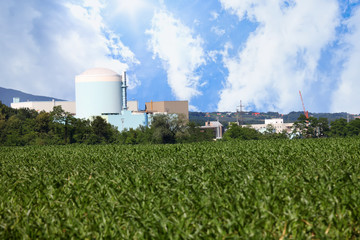 It is a nice sunny day. A nuclear power plant is seen in a distance. 