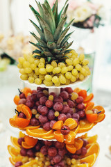 sliced fruits on a stand on a white table