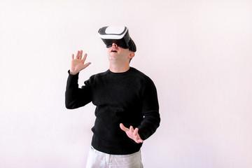 Man using a virtual glasses on white background. Young male business executive using virtual reality headset in office. Gays at office and using virtual reality glasses.