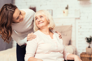 Amused woman taking care of her mother on wheelchair