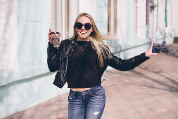 Young girl walking on the city streets with cofee