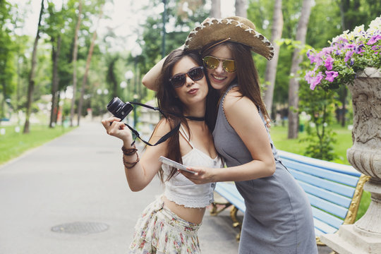 Outdoor portrait of two friends watching photos with a smartphone