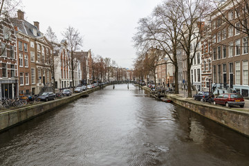 Fototapeta premium Amsterdam, March 17, 2017: Canals and house view from Amsterdam, where city of bikes, canals and peace